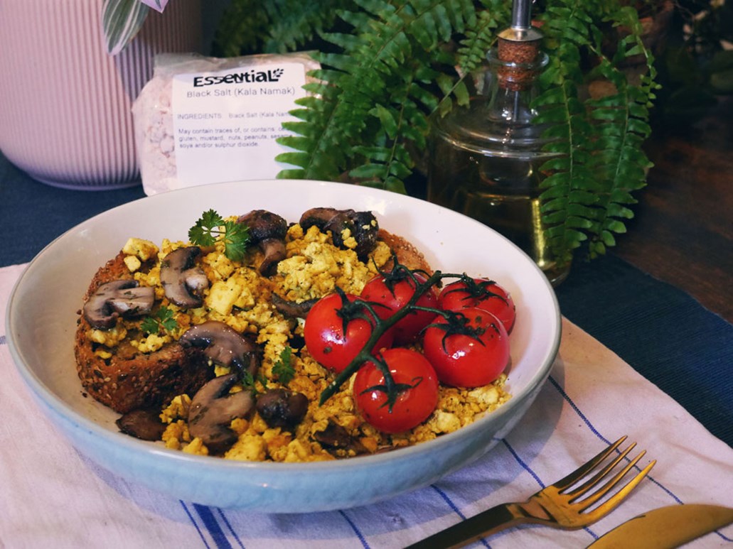 tofu scramble in a bowl with cooked vine tomatoes and mushrooms